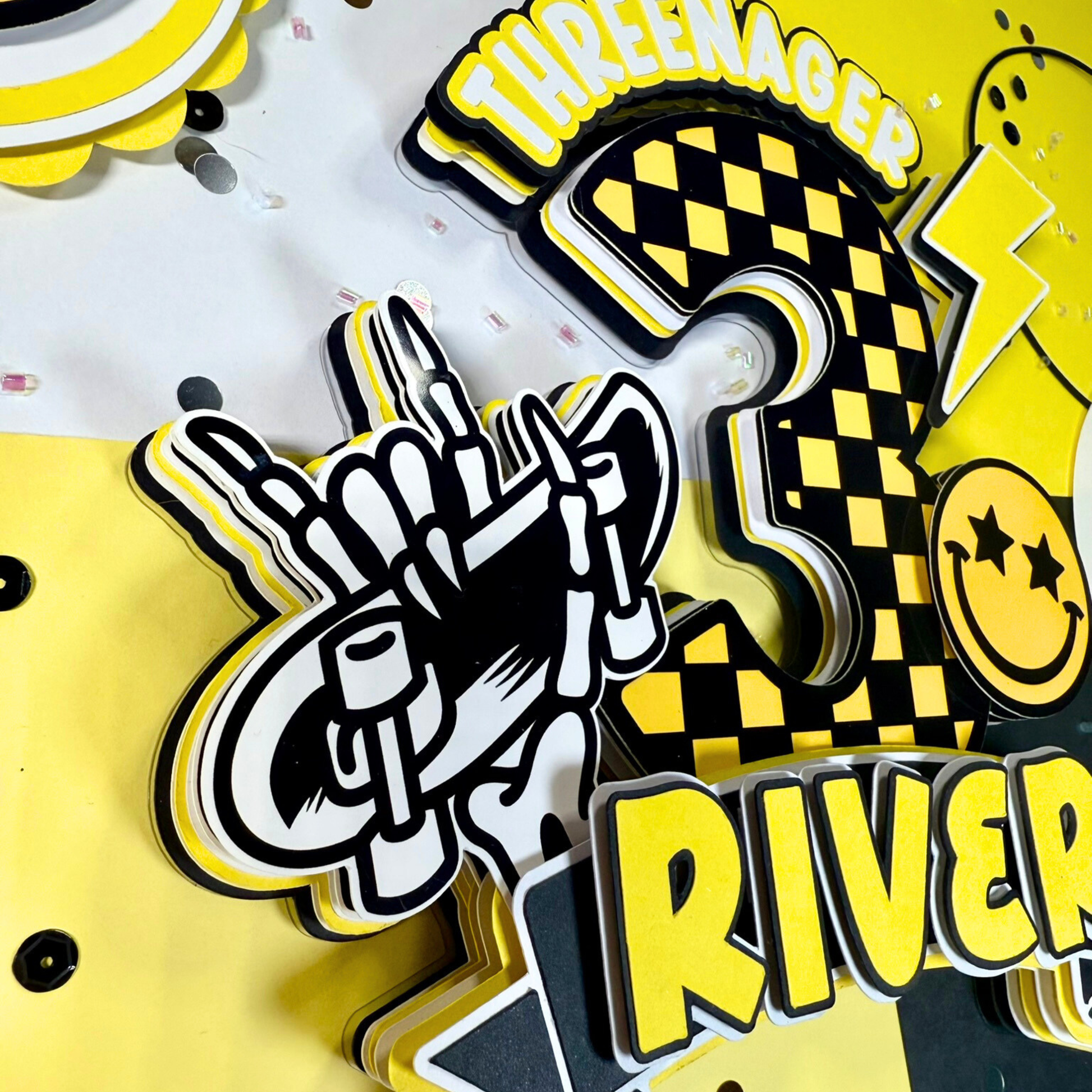 Decorative elements with a number '3', skeleton hand, and text on a yellow background