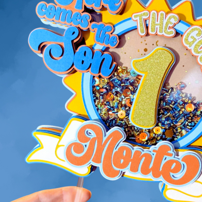 Decorative birthday cake topper with colorful text and number '1' against a blue background