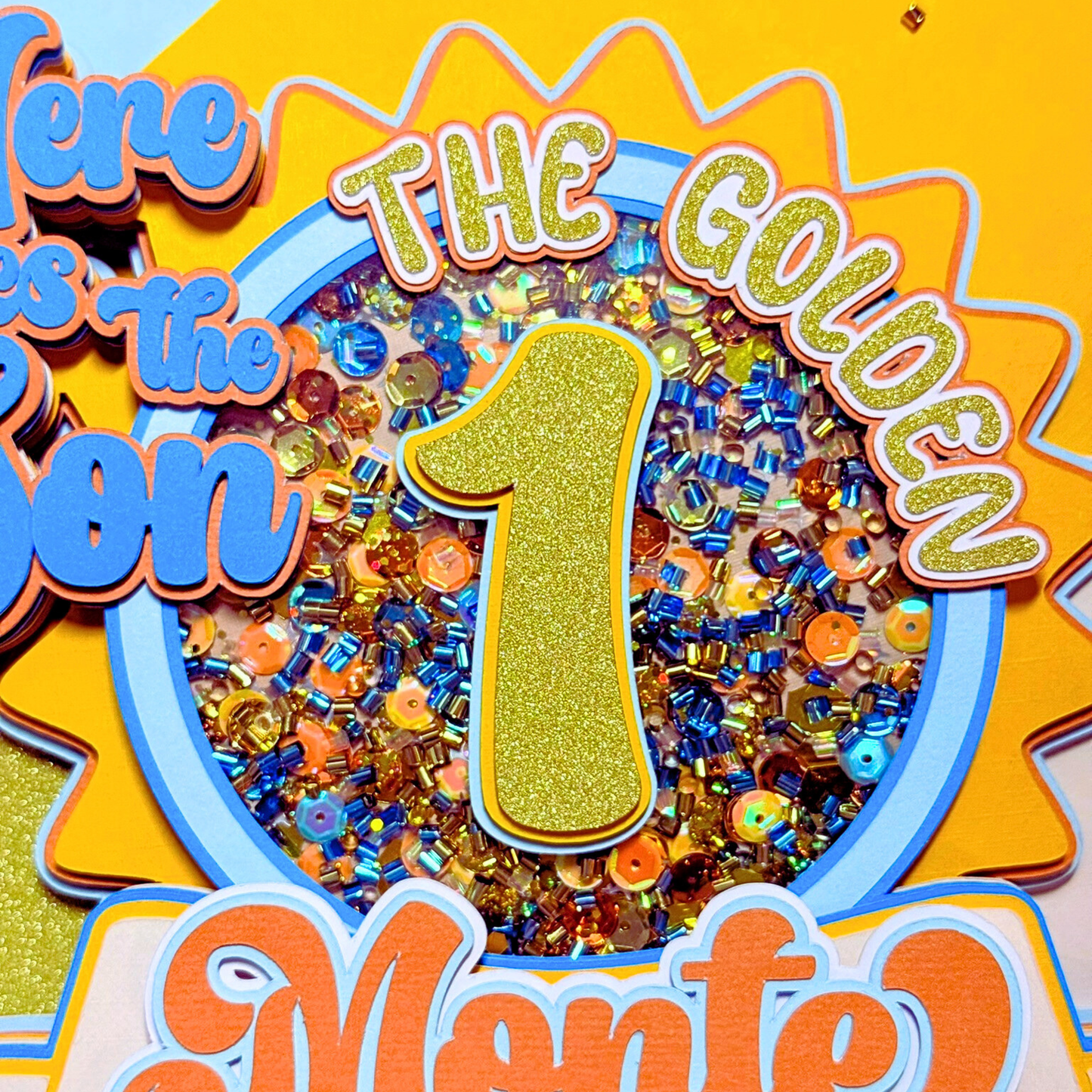 Decorative sign with colorful beads, number 1, and text on a yellow background
