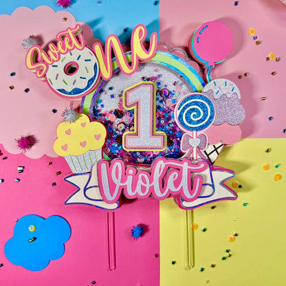 Colorful birthday cake topper with 'Sweet One Violet' on a multicolored background