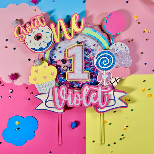 Colorful birthday cake topper with 'Sweet One Violet' on a multicolored background