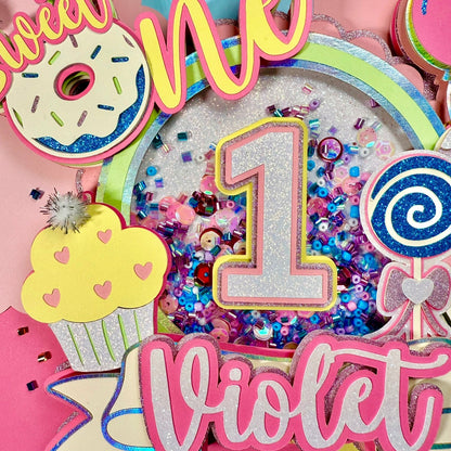 Colorful birthday decoration with 'sweet one' and number '1' for a first birthday party, featuring the name 'Violet'.